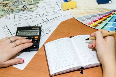 architectural plans with palette of colors, money, calculator, notepad